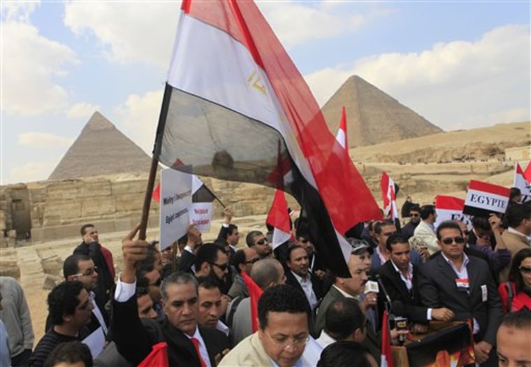 Hundreds of Egyptian tourist guides flash welcoming banners in different languages as a message to tourists during a march Monday in front of the historical site of Giza Pyramids. Egypt's ruling military council has issued a new communique calling on labor leaders to stop strikes and protests to allow a sense of normalcy to return to the country.